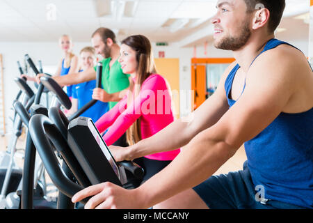 Männer und Frauen auf cardio Fahrräder in der Turnhalle Stockfoto