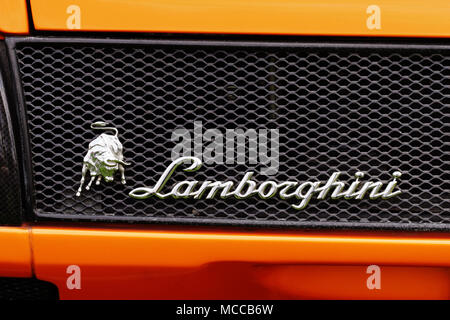 Closeup detail von Lamborghini Abzeichen Logo Branding Emblem und den berühmten Lamborghini Stier symbol Maskottchen auf der Rückseite einer orange Lamborghini Diablo GT. Stockfoto