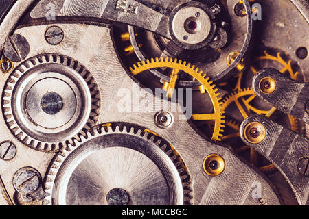 Uhrwerk Hintergrund. Nahaufnahme der Alten Uhr Uhrwerk. Retro Uhrwerk Uhrwerk mit Grau und Golden Gänge. Vintage Bewegung Mechanik Stockfoto