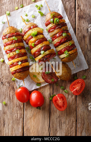 Shish Kebab aus Kartoffeln mit Würstchen am Spieß close-up auf einem Tisch. Vertikal oben Ansicht von oben Stockfoto