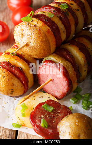 Gegrillte Kartoffeln mit Würstchen am Spieß close-up auf dem Tisch. Vertikale Stockfoto