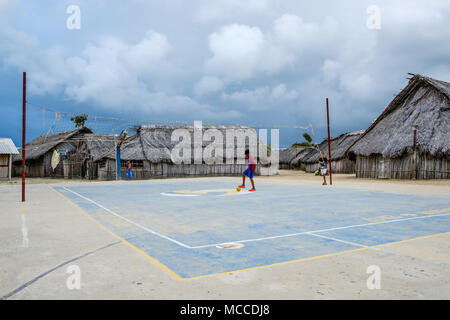 Guna Yala, Panama - März 2018: Junge mit Ball spielen Fußball in Kuna Dorf, San Blas Inseln. Kuna sind die indigenen Menschen in Panama Stockfoto