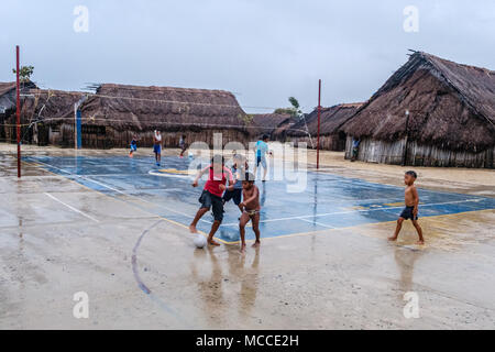 Guna Yala, Panama - März 2018: die Gruppe der Jungen Fußball spielen am Sportplatz in Kuna Dorf an einem regnerischen Tag - San Blas Inseln Stockfoto