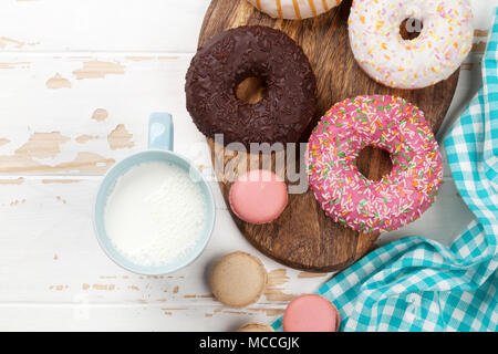 Milch, Makronen und Donuts auf Holztisch. Ansicht von oben mit der Kopie Raum Stockfoto