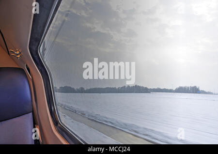 Aussicht von der Niederländischen Eisenbahn Zug auf einer verschneiten Winterlandschaft in der Nähe von Zwolle Stockfoto