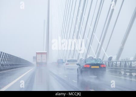 Autos überqueren der Queensferry Kreuzung in sehr nassen Fahrbedingungen, Fife, Schottland. Stockfoto