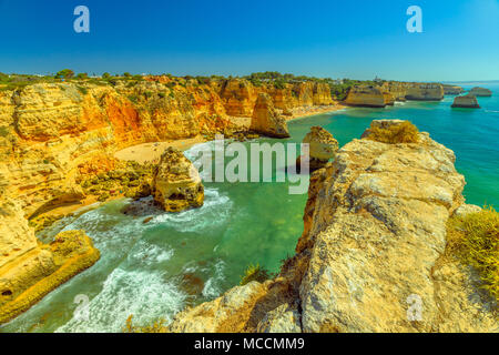 Luftaufnahme von hohen Felsen von Praia da Marinha in der Algarve, Portugal, Europa. Die malerische Landschaft von Marinha Beach, einem der schönsten Strände in Portugal. Sonnigen Tag in türkisfarbenem Wasser. Stockfoto