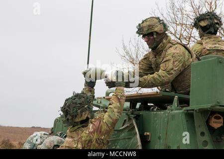 Spc. Rickey Wendorf (oben auf dem Fahrzeug), erhält einen 120 mm runde von Pvt. Tyler Donnell während einer Live Fire Übung auf grafenwöhr Training Area, Feb 8, 2018, Grafenwöhr, Deutschland. Beide Wendorf und Donnell werden als indirekte Feuer Infanterist in 2Nd Battalion, 70th Panzer Regiment, 2. gepanzerte Brigade Combat Team, 1.Infanterie Division. (U.S. Armee Foto: Staff Sgt. Sharon Matthias, 22 Mobile Public Affairs Abteilung) Stockfoto