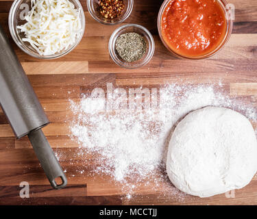 Die Zutaten für die Herstellung hausgemachte Pizza, einschließlich geriebenem Käse, pizza Sauce und Gewürze Stockfoto