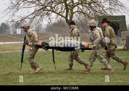 Spc. Wesley Hobson (R) in die 4. Staffel, 2d-Cavalry Regiment zugeordnet, und Sgt. Staci Daniel (R), zur 1. Staffel, 2CR, Spaziergang mit Soldaten aus 11 Leichte Infanterie Bataillon, 1 Infanterie Brigade der Georgischen Land Kräfte, wie sie in einem simulierten Unfall auf eine Landing Zone während einem Kampf Life Saver Kurs evakuieren Feb 9, 2018 an der Medizinischen Simulation Training Center in Grafenwöhr Training Area, Deutschland zugewiesen. Die soldaten Instruktion der Kurs vom 2.Kavallerie Regiments und 7th Army Training Befehl. (Foto: Staff Sgt. Jennifer Bunn) Stockfoto