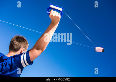 Kind flying a Kite in den klaren blauen Himmel. Stockfoto