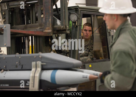 Älterer Flieger Kevin Clemons, zum 3 Munition Geschwader zugewiesen, betreibt ein Gabelstapler während Airman 1st Class Jonathan Catalano als er Boden führt ein Rack mit inerten kleiner Durchmesser Bomben bei Bereitschaft Ausbildung bei Joint Base Elmendorf-Richardson, Alaska, Feb 9, 2018. Der kleine Durchmesser Bombe ist eine präzise und genaue Waffe, mit der F-22 Raptor entscheidende Air Power zu liefern. (U.S. Air Force Foto von Alejandro Peña) Stockfoto