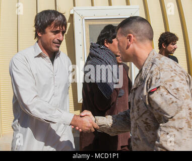 Ein Marine advisor mit Task Force Südwesten grüßt ein afghanischer Soldat an die Verwundeten Übergang Einheit im Camp Shorabak, Afghanistan, Feb 8, 2018 erholt. Sgt. Maj. Waheddin Wafa, command Sergeant Major der afghanischen Armee (ANA) 215 Corps, persönlich besucht jeder Soldat am Krankenhaus und der verwundete Übergang (WTU). Die wtu bietet medizinische Hilfe für Soldaten der Wiederherstellung nach Verletzungen und bereitet sie für den Übergang zurück in den aktiven Dienst oder für eine medizinische Entlastung. (U.S. Marine Corps Foto: Staff Sgt. Melissa Karnath/Freigegeben) Stockfoto