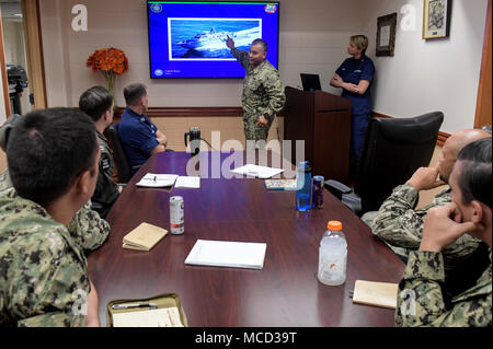 Lt.Cmdr. Paul Duenas, an die in den Küstenzonen Riverine Gruppe 1, Det zugeordnet. Guam, beschreibt top-side Hindernisse auf dem Mark VI Patrouillenschiff zu Hubschrauber Meer Combat Squadron 25 während einer Tisch- Übung, die Interoperabilität für einen gemeinsamen Such- und Rettungsaktion, Jan. 16, 2018 zu demonstrieren. CRG-1 Det. Guam ist zum Kommandanten, Task Force 75, die primäre Expeditionary task force verantwortlich für die Planung und Ausführung der Küstengebiete Riverine operations, Beseitigung von Explosivstoffen, tauchen Engineering und Bau zugeordnet und Unterwasser Bau in den USA 7 Flotte Bereich der Operationen. (U.S. Stockfoto