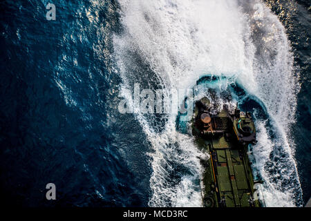 Ein amphibisches Fahrzeug 3 Assault Amphibian Bataillon Spritzer im Ozean zugeordnet die Amphibious Assault ship USS BONHOMME RICHARD (LHD-6), vor der Küste des Königreichs Thailand, Feb 16, 2018. Marines sind die Teilnahme an einem multilateralen Amphibische Operation mit ihren Royal Thai und Republik Korea Navy und Marine Corps. Cobra Gold 18 ist Thai-US-co-gesponsert Übung im Königreich Thailand von Feb.13-23 mit sieben voll teilnehmenden Nationen. Das Bataillon ist vorausschauend zu bekämpfen Angriff Bataillon eingesetzt, 3rd Marine Division als Teil einer Einheit deployme Stockfoto