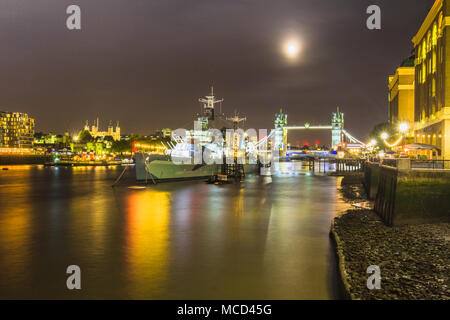HMS Belfast, Themse, die Tower Bridge und dem Tower von London gesehen aus dem Rathaus bei Nacht South Bank, London, England, UK mit Reflexionen Stockfoto
