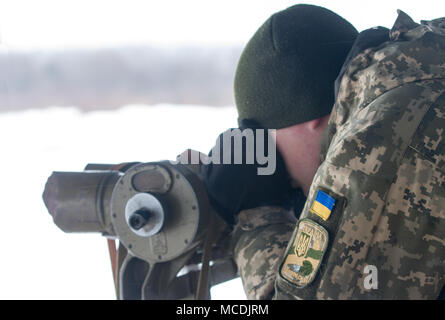 Yavoriv, der Ukraine Ukrainische Armee Soldat beobachtet ein T-64B Tank live-fire Übung durch die ukrainische Armee Soldaten des 3.BATAILLON zugeordnet durchgeführt, 14 mechanisierte Brigade an der Yavoriv Combat Training Center (CTC) hier Feb 14. Derzeit 3-14 Th ist Abschluss einer Ausbildung Rotation an der CTC, wo sie von den US-amerikanischen, kanadischen, Litauisch, Polnisch betreut wird, und Großbritannien service Mitglieder, wie sie bei der Erreichung ihrer Ziel der NATO-Interoperabilität bemühen. (U.S. Armee Foto von Sgt. Alexander Rektor) Stockfoto