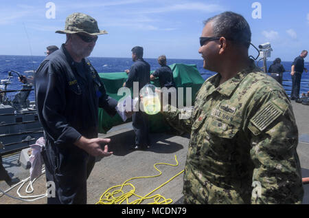 Chief Warrant Officer Jim Dewitt, der Arleigh-burke-Klasse geführte Anti-raketen-Zerstörer USS O'Kane (DDG77), beschreibt die Reinheit der Marine Diesel Kraftstoff in O'Kane's Service Panzer Lt.Cmdr. Paul Duenas, an die in den Küstenzonen Riverine Group (CRG) 1, Det zugeordnet. Guam, während einer Übung Prüfung - auf See - auftanken Funktionen zwischen Mark VI Patrouillenboote und O'Kane, Feb 21, 2018. CRG-1, Det. Guam, ist in der Lage, leitende Maritime Security Operations in das gesamte Spektrum der Naval, Joint und Combined Operations. Es bietet zusätzliche Funktionen von Port Security, Security begonnen, ein Stockfoto