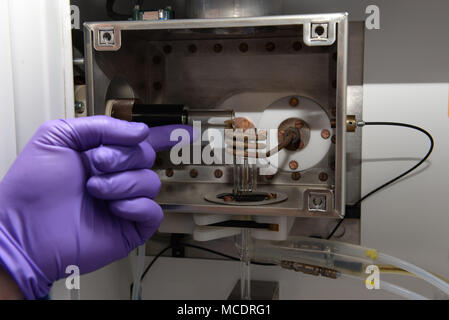 Robert Rechnungen, Luft- und Raumfahrt Brennstoffe Laborchemiker, weist auf die induktionsspule und Fackel der inductively coupled plasma optical emission Spectrometer (ICP/OES) in der investigativen Analyse Labor in der wright-patterson Air Force Base, Ohio, 13.02.2018. Rechnungen erklärte, wie die ICP/OES hat ein ähnliches Prinzip, Feuerwerk, wo verschiedene emittiert, um Farben auf die Anwesenheit von bestimmten Metallen in Verbindung gebracht werden können. (U.S. Air Force Foto von Michelle Gigante) Stockfoto