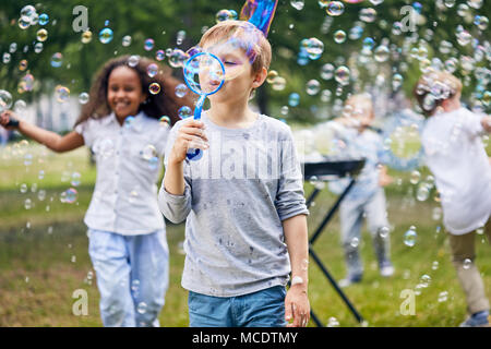 Frohe Kinder machen Seifenblasen Stockfoto