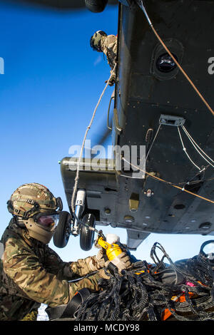 Ein Vereinigtes Königreich Royal Marine beteiligt sich an Hubschrauber Support Team Training neben der US-Marines mit Marine Drehkraft 17.2 während der Übung weiß Claymore in Bardufoss, Norwegen, Jan. 20, 2018. Weiß Claymore ist eine Gemeinsame bi- arktische Kälte training Package führte durch das Vereinigte Königreich Royal Marines zu schulen, die gute Kenntnisse in kaltem Wetter Operationen auszuwerten und strategische Zusammenarbeit und Partnerschaft zwischen den US-Marines und U.K. Royal Marines verbessern. (U.S. Marine Corps Foto von Cpl. Careaf L. Henson/Freigegeben) Stockfoto