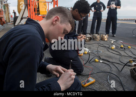 180223-N-NB 544-177 GOLF VON THAILAND (Feb. 23, 2018) Elektriker Mate's 3.Klasse Corey Williams, Hurst, Texas, und Elektriker Mate's Feuerwehrmann Lauren Tillman, aus Chicago, bereiten Wasserlinie Sicherheitsbeleuchtung für den Betrieb auf dem Flugdeck des Amphibious Assault ship USS BONHOMME RICHARD (LHD6) als das Schiff in Laem Chabang, Thailand ankommt, für einen geplanten Hafen besuchen. Bonhomme Richard hat seine Teilnahme an der Übung Cobra Gold 2018 neben Royal Thai Navy Schiffe und Personal abgeschlossen, da es eine Reihe von Amphibischen Operationen, taktische Know-how der Teil zur Verbesserung durchgeführt. Stockfoto