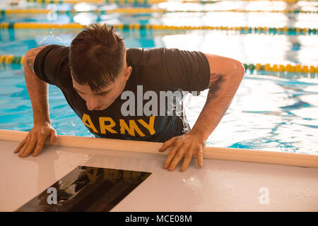 Us-Armee Sgt. Jacobus Holz, auf die Brüsseler Militär Polizei in der US-Armee Garnison Benelux zugeordnet, klettert aus dem Wasser während der Garnison besten Krieger Wettbewerb in der Swimmingpool im Obersten Hauptquartier der Alliierten Mächte Europa, Belgien, Jan. 21, 2018. (U.S. Armee Foto von visuellen Informationen Spezialist Pierre-Etienne Courtejoie) Stockfoto