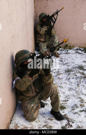 Georgische Soldaten von Charlie Company, 11 Leichte Infanterie Bataillon, 1 Infanterie Brigade Sicherheit zu bieten, dabei aber eine situative Training während einer Mission rehearsal Übung (MRE) bei der US-Armee Joint Multinational Readiness Center in Hohenfels, Deutschland, Feb.14, 2018 leiten. Die MRE ist ein US Marine Corps führen Übung mit fast 900 Soldaten aus Georgien, Ungarn und den USA die MRE auf der aktuellen Betriebsumgebung basiert und umfasst Lektionen gelernt, um die 11 Inf vorzubereiten. Bn. (Georgisch) für offensive und defensive Operationen, und einen Einsatz in Stockfoto