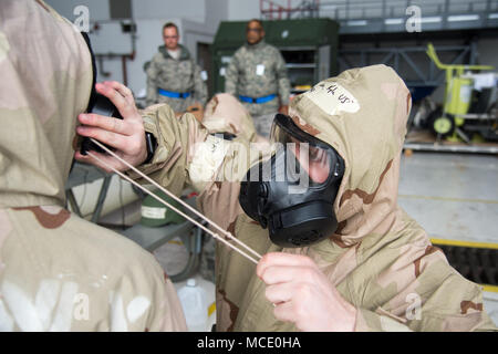 Airman Kyle Wilson, 736Th Aircraft Maintenance Squadron aerospace Wartung Lehrling, hilft einem Kollegen ihre Haube um ihr Gas Maske anziehen, während die 2018 Vengeant Eagle Übung Feb.22, 2018 in Dover Air Force Base, Del Alle US-service Mitglieder werden geschult, um Don ihr Gas Mask in neun Sekunden klar und und muss nicht alle Ihre MOPP (Mission Oriented schützende Haltung) in zwei Minuten oder weniger. (U.S. Air Force Foto von Mauricio Campino) Stockfoto