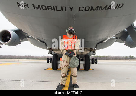 Airman 1st Class Jared Adams, 436Th Squadron Antenne Port cargo Prozessor, steht unter einem C-5 M Super Galaxy tragen volle MOPP gear während der 2018 Vengeant Eagle Übung Feb.22, 2018 in Dover Air Force Base, Del Adams das Flugzeug gemarshallt und dann beim Entladen der Fracht unterstützt. (U.S. Air Force Foto von Mauricio Campino) Stockfoto