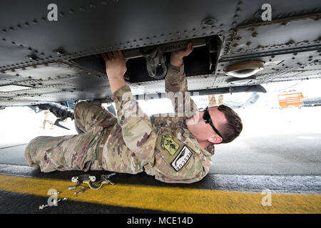 Einen Flieger aus dem 723 d Aircraft Maintenance Squadron (AMXS), greift nach einer Ladung Haken von unten ein HH-60 G Pavehawk, Februar 27, 2018, bei Moody Air Force Base, Ga, die Sie auf Ihre Fähigkeit der Schwanz und die Rotoren eines Pavehawk zu entfalten zu üben, dass der Hubschrauber in einer begrenzten Zeit ausgewertet wurden. (U.S. Air Force Foto von Airman Eugene Oliver) Stockfoto