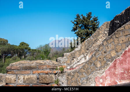 Schichten der Geschichte in die Backsteinwände und die verbleibenden freien am Pompeji mit Mt. Vesuv im Hintergrund, Pompeji Archäologischen Park, Italien. Stockfoto