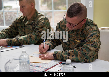 Generalleutnant Robert Hedelund, Kommandierender General, II Marine Expeditionary Force, Zeichen einer Überprüfung während der Navy-Marine Corps Fhv Kick off im Club des Offiziers auf der Marine Corps Base Camp Lejeune, N.C., Jan. 20, 2018. Die NMCRS ist ein Programm, das finanzielle, pädagogische und andere Unterstützung der Mitglieder der Naval Service der Vereinigten Staaten. (U.S. Marine Corps Foto von Lance Cpl. Damaris Arias) Stockfoto