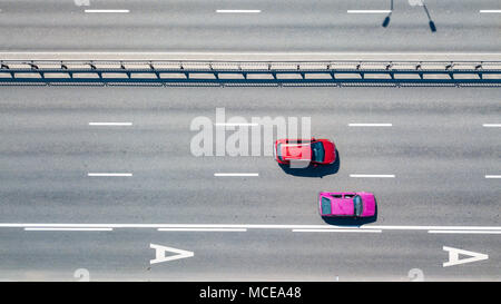 Luftaufnahme des roten und rosa vorbeifahrende Autos entlang der Straße an einem sonnigen Tag. Kiew, Ukraine. Drone Fotografie Stockfoto