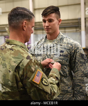 Us-Armee Generalmajor Malcom Frost, Zentrum für Erste militärische Ausbildung kommandierender General, Stifte die grundlegenden Armee Instructor Abzeichen auf der US-Air Force Staff Sgt. Casey Andersen, 362 Training Squadron, Distanz 1 HH-60 Hubschrauber Crew Chief Instructor, an Joint Base Langley-Eustis, Virginia, 9. April 2018. Während die AIB nur rund vier Jahre gewesen ist, Air Force Ausbilder haben ein Teil von Fort Eustis' 128 Aviation Brigade für 33 Jahre gewesen. (U.S. Air Force Foto: Staff Sgt. Teresa J. Cleveland) Stockfoto