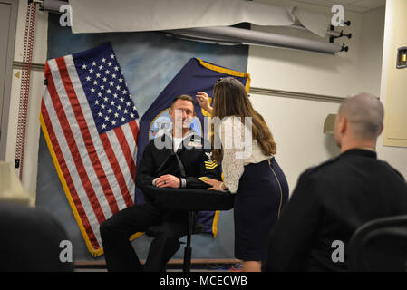 Das United States Navy Reserve Sailor of the Year-Programm ehrt jedes Jahr einen leistungsstärksten Reservist. Die 2017 ausgewählten Personen nahmen an einer Studio-Porträtsitzung im Pentagon teil. Das Archivbild dokumentiert den Seeleute, der während des formellen Porträtprozesses im Hauptquartier des Verteidigungsministeriums unterstützt wird. Stockfoto