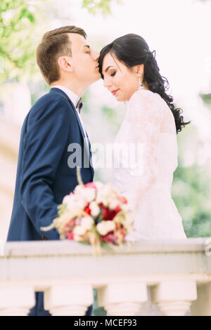 Der Bräutigam ist die Braut küssen in der Stirn. Brustbild. Stockfoto