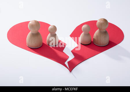 Holz- Schachfiguren auf Broken rotes Herz auf weißem Hintergrund Stockfoto