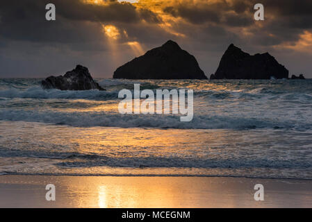 Sonnenuntergang über dem ikonischen Carters Felsen (Gull Felsen) bei Holywell Bay in Cornwall. Stockfoto