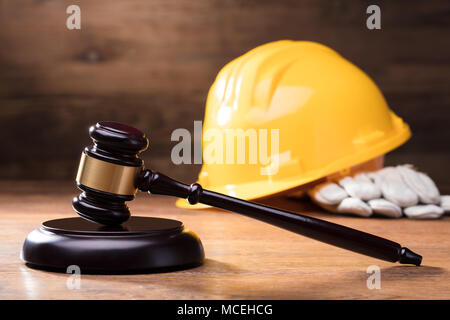 Richter Hammer Vor gelben Helm auf dem hölzernen Tisch Stockfoto