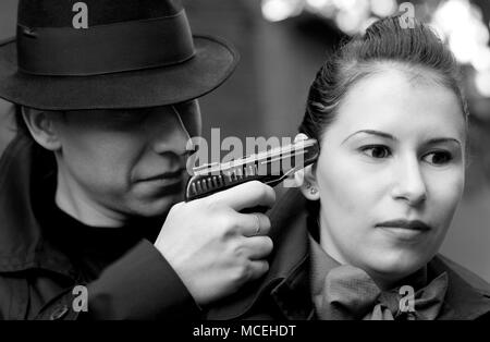 Monochrome Portrait von Mann bedroht die Frau mit einer Pistole Stockfoto