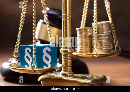 Close-up Blau Absatz Block Balancing mit Münzen Stapel auf der goldenen Waage der Gerechtigkeit Stockfoto