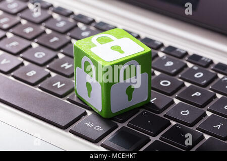 In der Nähe von Schloss Symbol auf der grünen Holz- Block über dem Laptop Tastatur Stockfoto