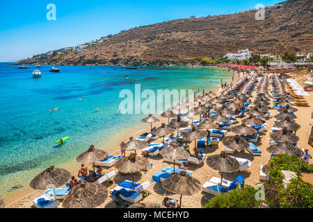 Reihen von Sonnenschirmen und Liegestühle am Strand. Psarou Beach. Insel Mykonos. Ciclades Inseln. Griechenland Stockfoto