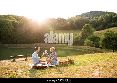 Senior Paar am See bei einem Picknick. Stockfoto