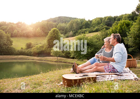 Senior Paar am See bei einem Picknick. Stockfoto