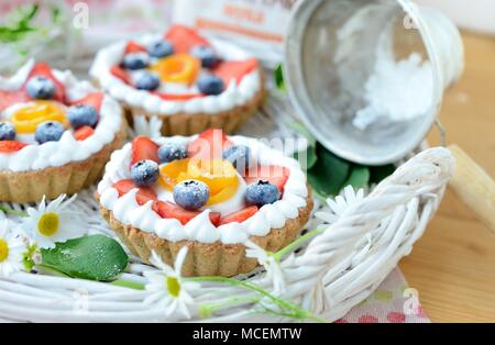 Kleinen Korb geformte Tarte mit Birnen, Erdbeeren und Sahne Stockfoto