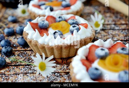 Kleinen Korb geformte Tarte mit Birnen, Erdbeeren und Sahne Stockfoto