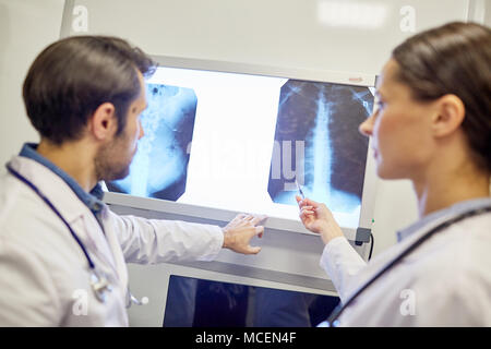 Ärztin zeigen an x-ray Image und Beratung mit ihrem Kollegen Stockfoto