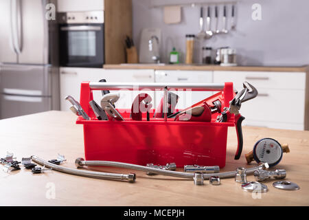 Toolbox mit unterschiedlichen Worktools auf hölzernen Schreibtisch Stockfoto